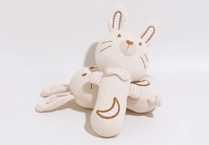 Close-up of rabbit baby rattles made of organic cotton with moon embroidery detail