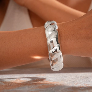 Macro shot of a thick silver twisted rope bracelet with a high-polished mirror finish
