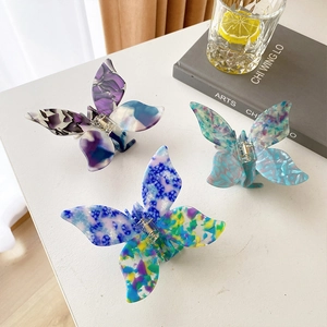 Elegant butterfly hair claws in acetate material with floral and marble patterns