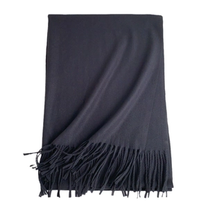 Classic soft black cashmere-like winter scarf with elegant tassels on white background