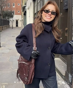 Detail of navy blue wool jacket with large buttons and vintage brown leather crossbody bag