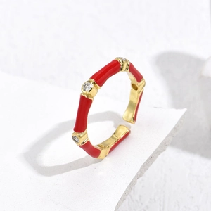 Detail of red enamel bamboo ring with gold plating and three round zircon stones