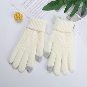 Close-up of white knit gloves with grey touchscreen tips and warm textured jacquard pattern