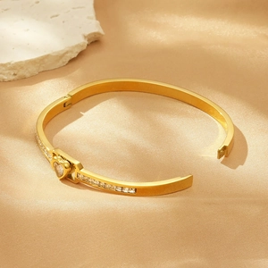 Gold plated stainless steel open bangle with heart charm and square zircon stones