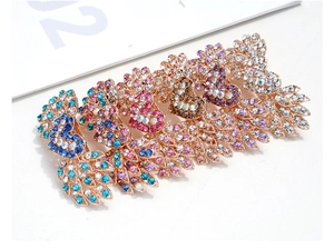 Dettaglio di fermagli per capelli ali d'angelo con strass colorati su oro rosa