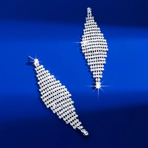 Detailed macro view of long silver rhinestone fringe earrings with luxury starburst effect