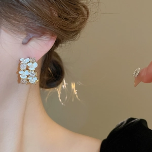 Elegant gold flower earrings with white petals, small pearls and sparkling zircons
