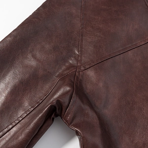 Gros plan sur la texture du cuir vintage marron foncé et les coutures détaillées de la veste