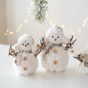Plush knitted snowman figurine with wood buttons and warm bokeh background lights