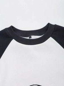 Close-up of the ribbed crewneck with M-size label on a black and white raglan sweatshirt