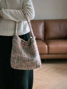 Detail of colorful woven tweed tote bag with vibrant knit texture and sturdy top handles