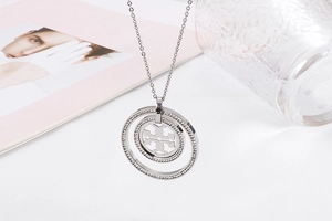 Detail of silver stainless steel necklace with double T hollow pendant and crystal border