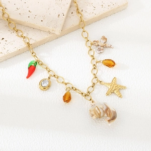Détail du collier en acier inoxydable doré avec breloques étoile de mer et dauphin