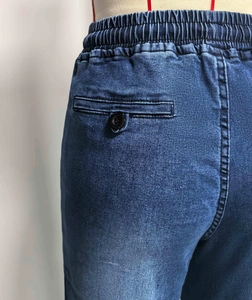 Detail van elastische taille met koord en achterzak van de donkerblauwe rechte spijkerbroek