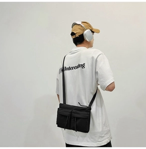 Detail of nylon messenger bag featuring adjustable straps and dual front utility pockets