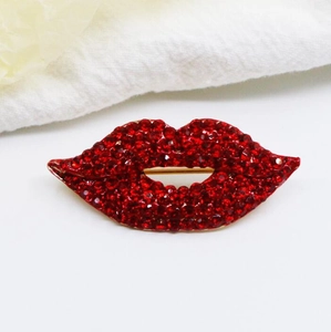 Detail shot of the red rhinestone pavé lip brooch with a golden alloy base setting