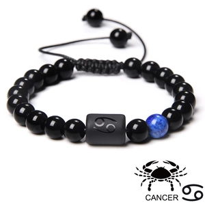 Macro detail of Cancer zodiac beaded bracelet with black polished beads and blue stone