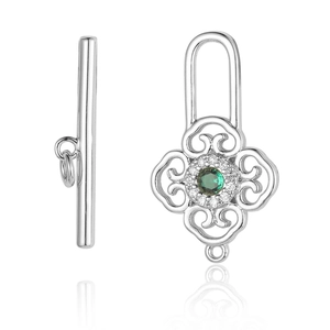 Détail du fermoir à bascule argenté avec zircone verte ronde et motifs filigranes