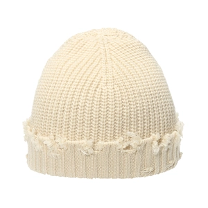 Close-up of off-white knitted beanie showing distressed edges and thick texture