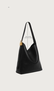 Detail der schwarzen Leder-Tote-Bag mit goldener Schnalle und verstellbarem Riemen