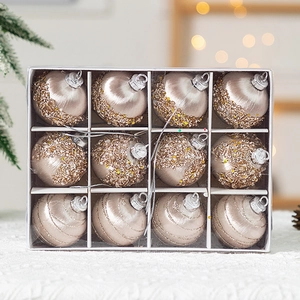 Vue détaillée de boules de Noël pailletées et texturées champagne doré en boîte cadeau de 12