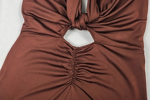Detail shot of the front knot and cut-out design on a brown backless bodycon maxi dress