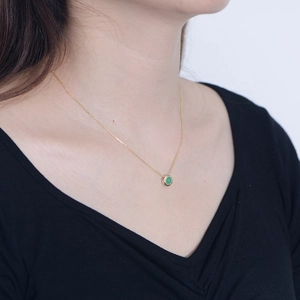 Close-up of a s925 silver necklace with a green agate pendant on a female model