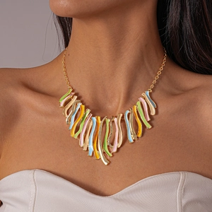 Detail of colorful irregular wavy enamel pendants on a gold chain tassel necklace