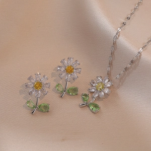 Daisy jewelry set with sparkling zircon flower necklace and earrings on silk background