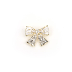 Elegant gold bow brooch with baguette crystals and round zircons on a white background