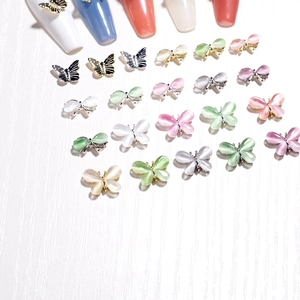 3D-Cat-Eye-Schmetterlings-Nageldekoration in verschiedenen Farben auf weißem Holz