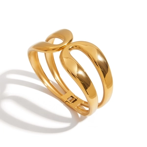 Polished gold wide cutout bangle in stainless steel with a streamlined openwork design
