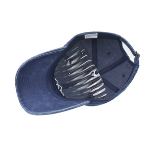 Detail of navy washed cotton baseball cap interior with metal buckle and laundry label