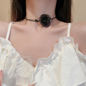 Detail view of a double-layered black lace choker featuring a 3D floral mesh ornament