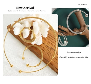 Detail shot of woven texture gold and silver jewelry sets on a natural wood and coral base