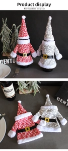 Detail of Christmas knitted wine bottle cover set with Santa hat and coat decorations