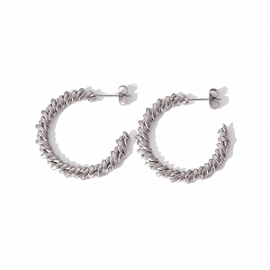 Détails de la texture torsadée argentée sur les boucles d'oreilles en forme de C en acier