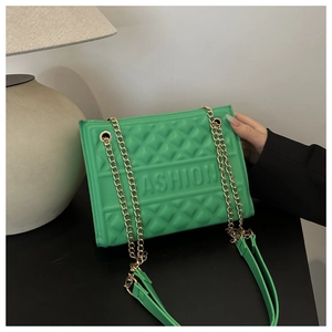 Detail of green embossed handbag with golden chain strap and FASHION lettering