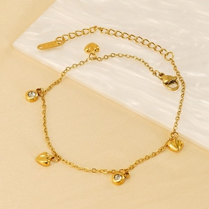 Detail of 18K gold plated heart and zircon charms on an elegant dainty bracelet chain