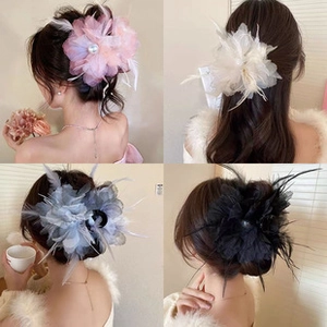 Detailed view of handmade feather hair clips with tulle and pearls in four elegant colors