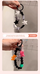 Detail showing a silver balloon dog pendant and colorful star beads on a stylish keychain