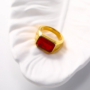 Macro shot of gold plated titanium ring featuring a rectangular red gemstone inlay