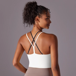 Vue détaillée du dos d'un soutien-gorge de sport blanc avec bretelles croisées noires