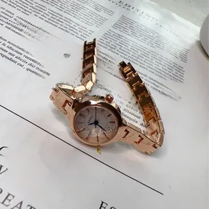 Close-up of rose gold watch with rhinestone markers and polished metal link strap
