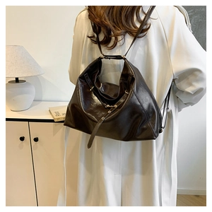 Detail of dark brown leather backpack texture with adjustable straps on a model in white coat