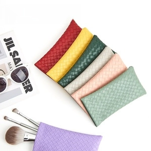 Detail view of woven leather texture glasses pouches in seven vibrant colors on white background