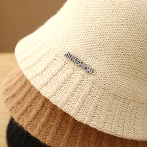 Macro detail of striped crochet bucket hats with diamond letter metal logo decoration
