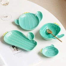 Detailed view of creative cactus shaped green ceramic plates and bowls set on table