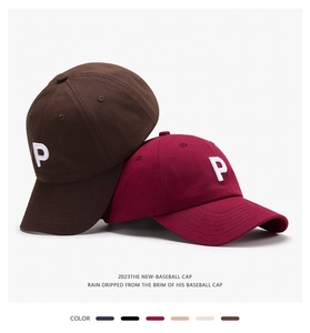 Detail of embroidered P letter on cotton baseball caps in brown and burgundy colors