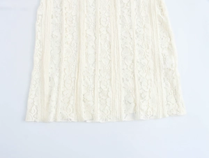 Detailed macro view of delicate white floral lace fabric and intricate hem embroidery